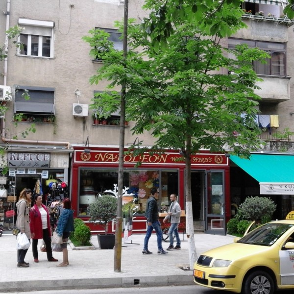 Sami Frasheri utca. A Napoleon üzlet kirakata mutatja, hogy francia termékek is kaphatók bőségesen, és megfér a francia bolt két olasz között.